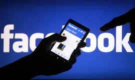 logo do facebook com uma mão segurando um celular